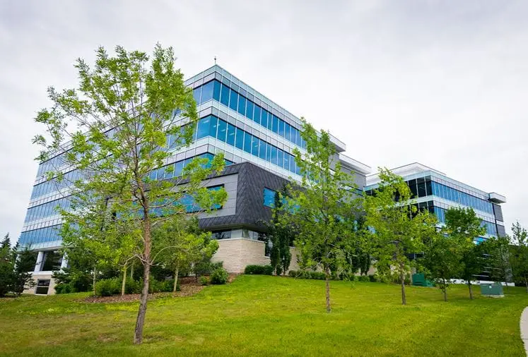 Fusion Collegiate's campus inside the Calgary Charter Hub building, framed by trees against an overcast Alberta sky.