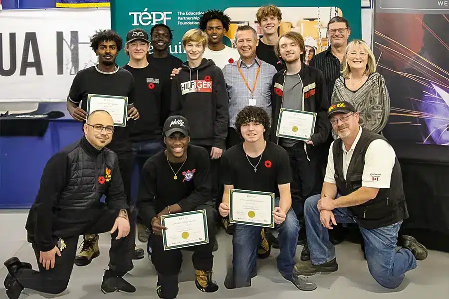 Fusion Collegiate students and instructors standing together with TEPF certificates of completion at a skilled trades event.